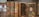 Several antique books with textured, rustic covers are displayed alongside wooden cases containing botanical specimens. The spines of the books have decorative red labels, while the specimens in the open cases appear to be pressed leaves and other plant materials.
