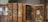 Several antique books with textured, rustic covers are displayed alongside wooden cases containing botanical specimens. The spines of the books have decorative red labels, while the specimens in the open cases appear to be pressed leaves and other plant materials.