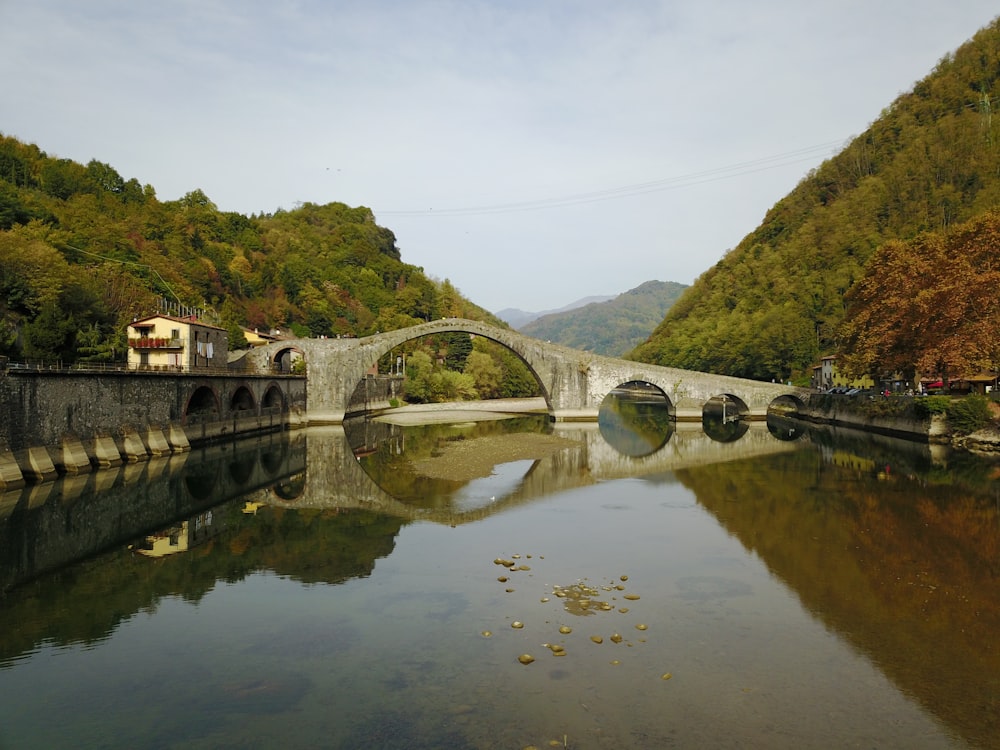 river with bridge between mountains