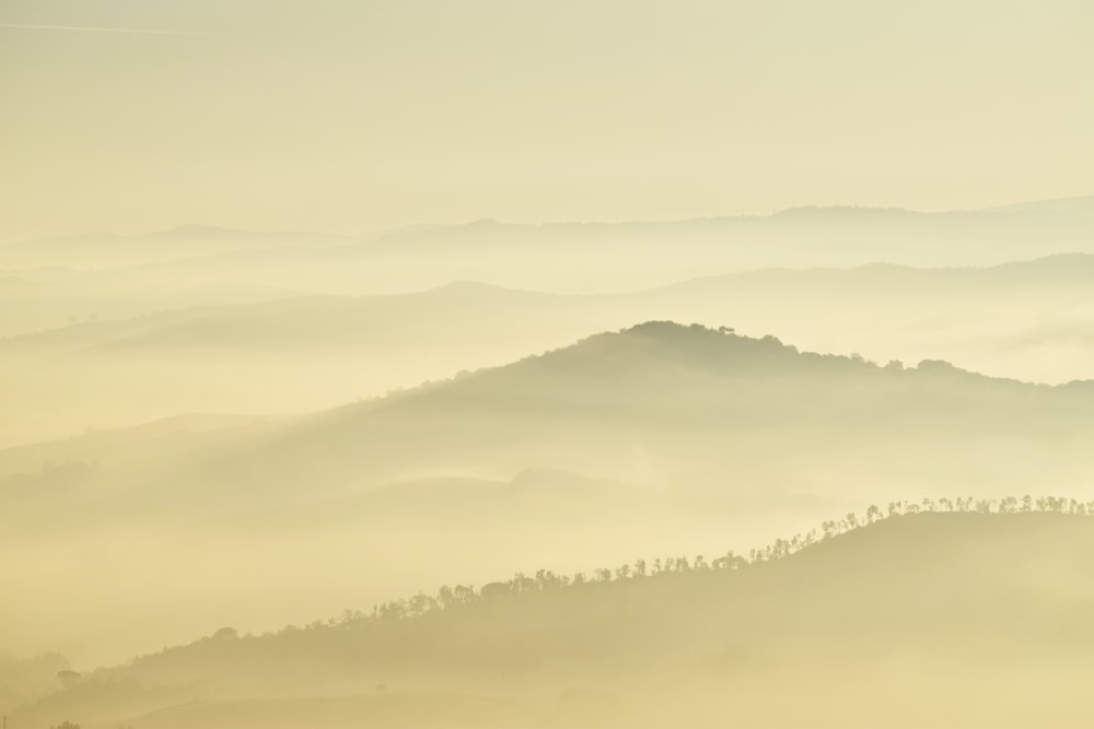 Fotografia de paisagem de montanhas durante o dia de nevoeiro