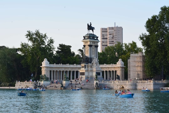 photo of concrete monument near body of water in El Retiro Park Spain