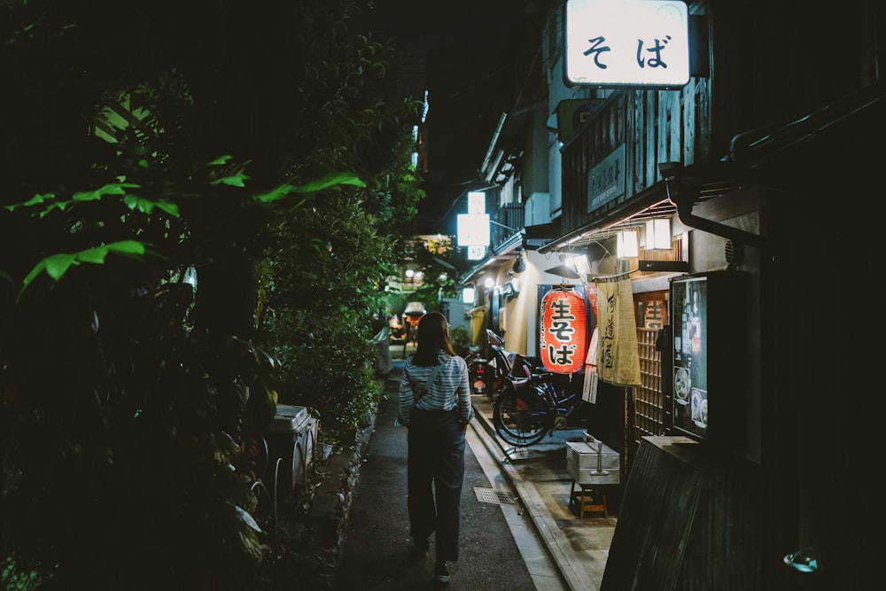 woman walking on pathway at night time