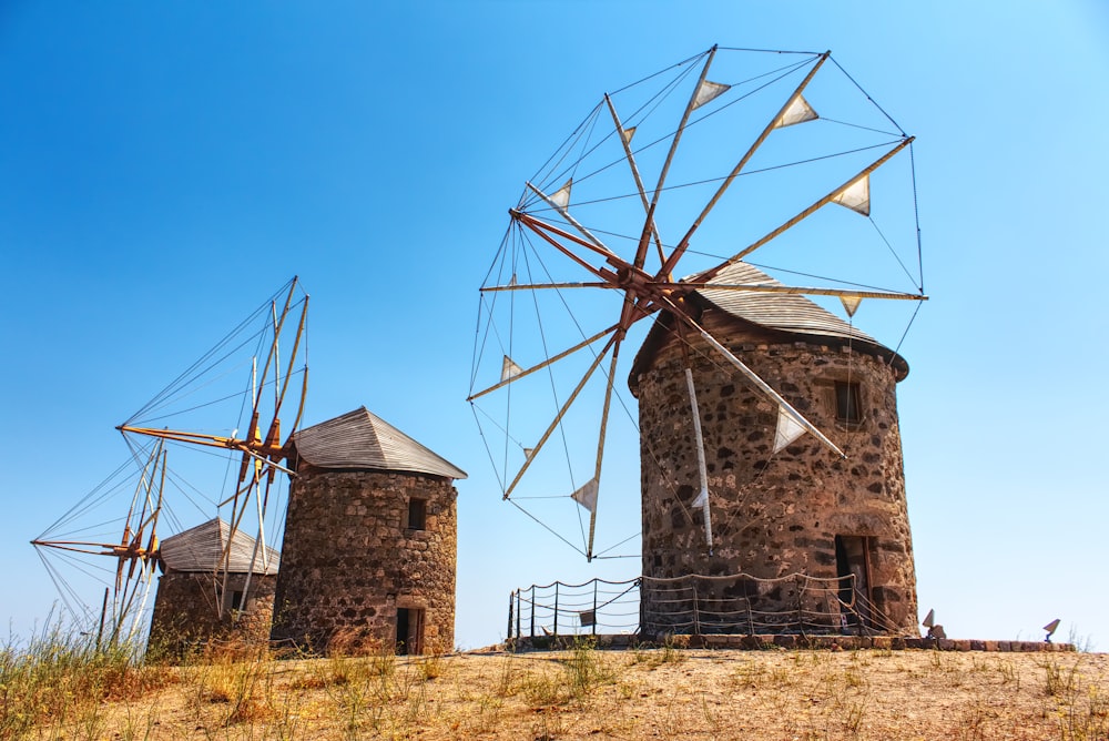 three brown windmills on hill