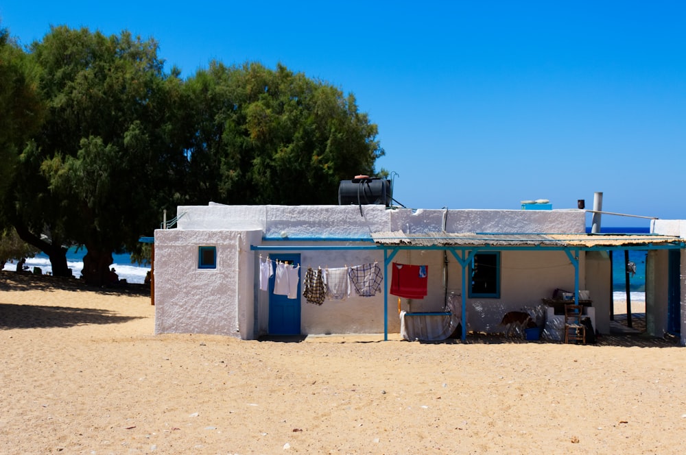 Casa de hormigón blanco cerca de árboles verdes bajo el cielo azul durante el día