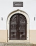 brown wooden door between white concrete wall
