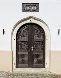 brown wooden door between white concrete wall