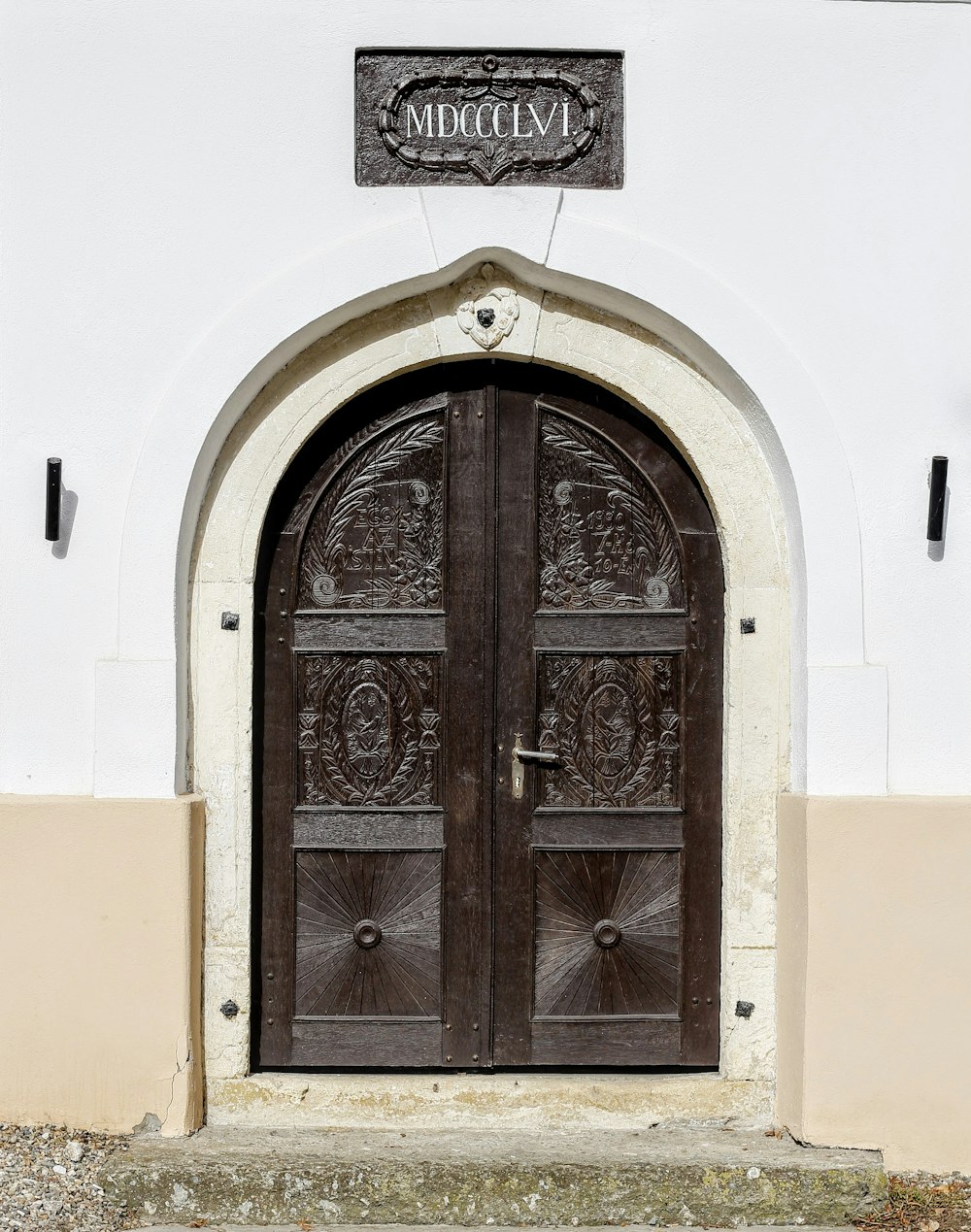 흰색 콘크리트 벽 사이의 갈색 나무 문