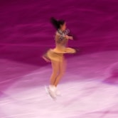 woman in beige performing ice skate