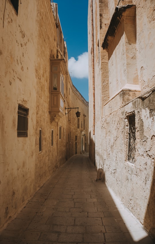 road between two buildings during daytime in Mdina Malta