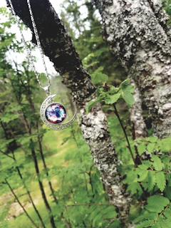 A layered display of zodiac pendants symbolizing family connections, set against a soft celestial backdrop.