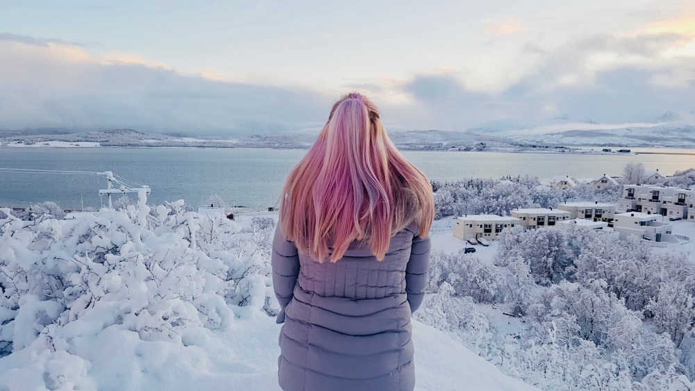 woman in gray long-sleeved top standing in front of snow