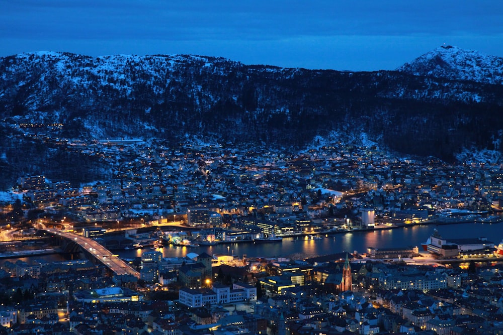 gray high-rise buildings surrounded with mountains at night time