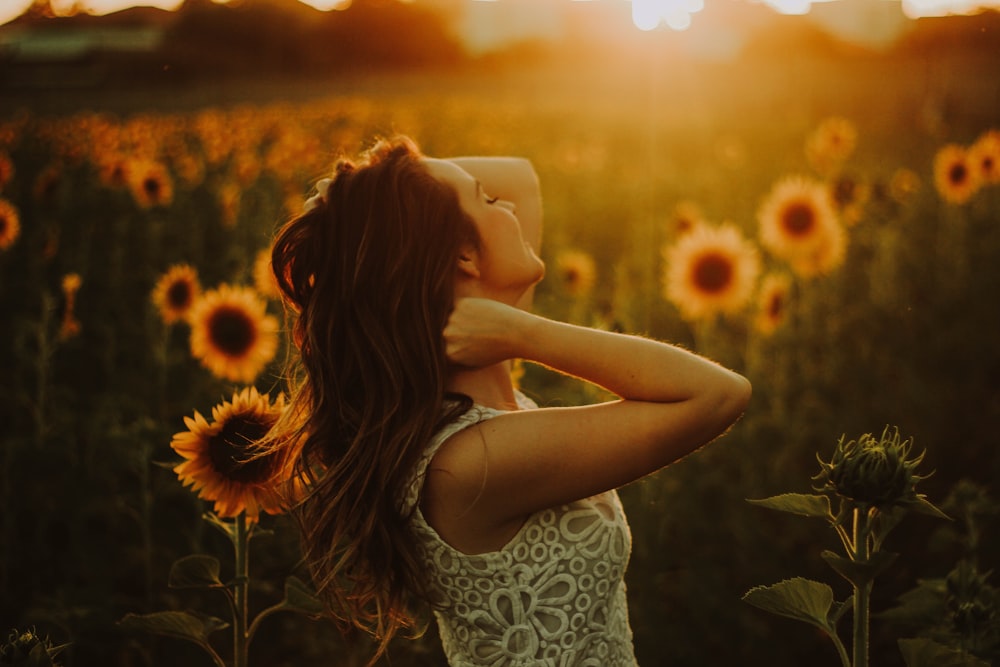 Frau steht in der Nähe von Sonnenblumenfeld