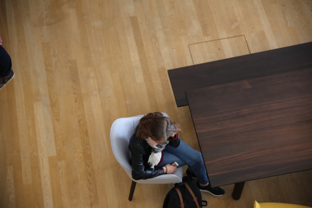 woman sitting on gray chair near brown table