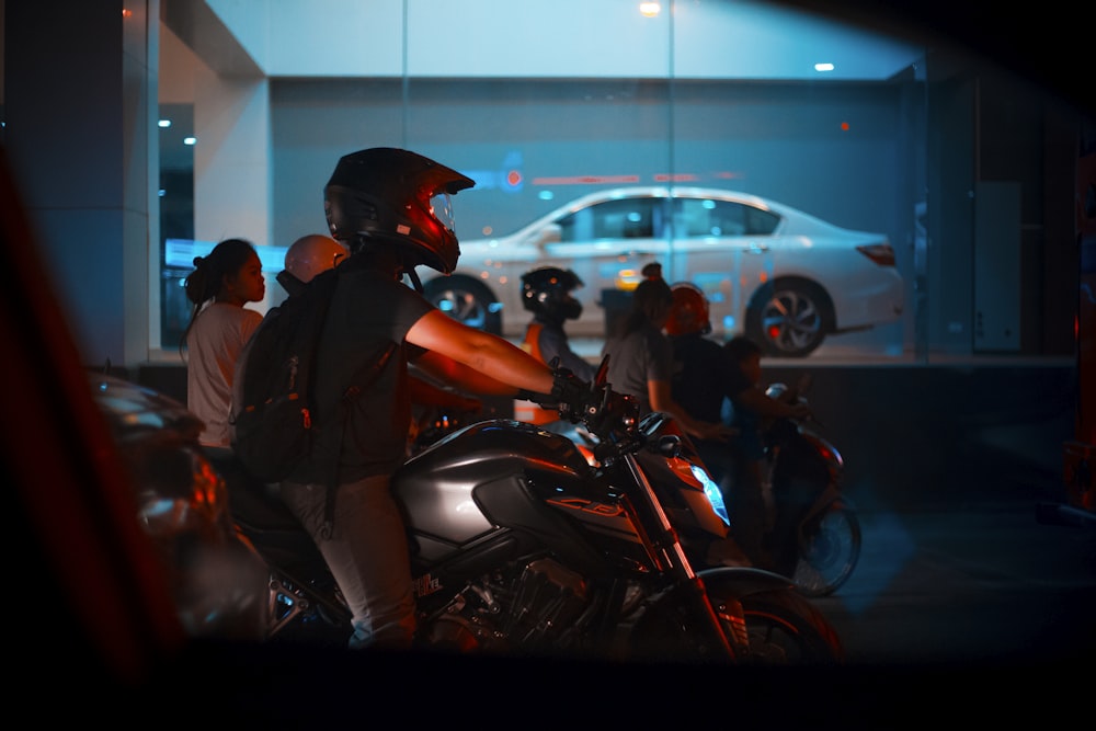 man riding gray naked motorcycle near people