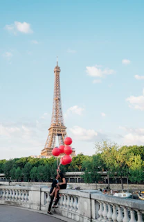 A romantic couple enjoying a candlelit dinner overlooking the Eiffel Tower sparkling at night.