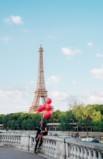 Couples holding hands inside the basket, with colorful balloons floating gently above.
