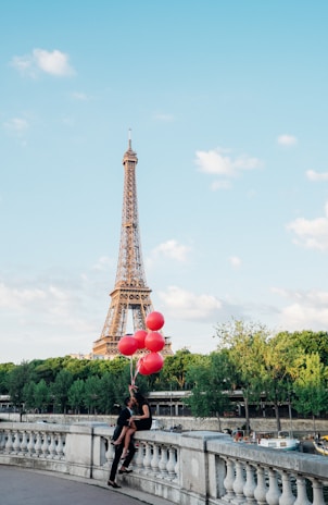Couples holding hands inside the basket, with colorful balloons floating gently above.