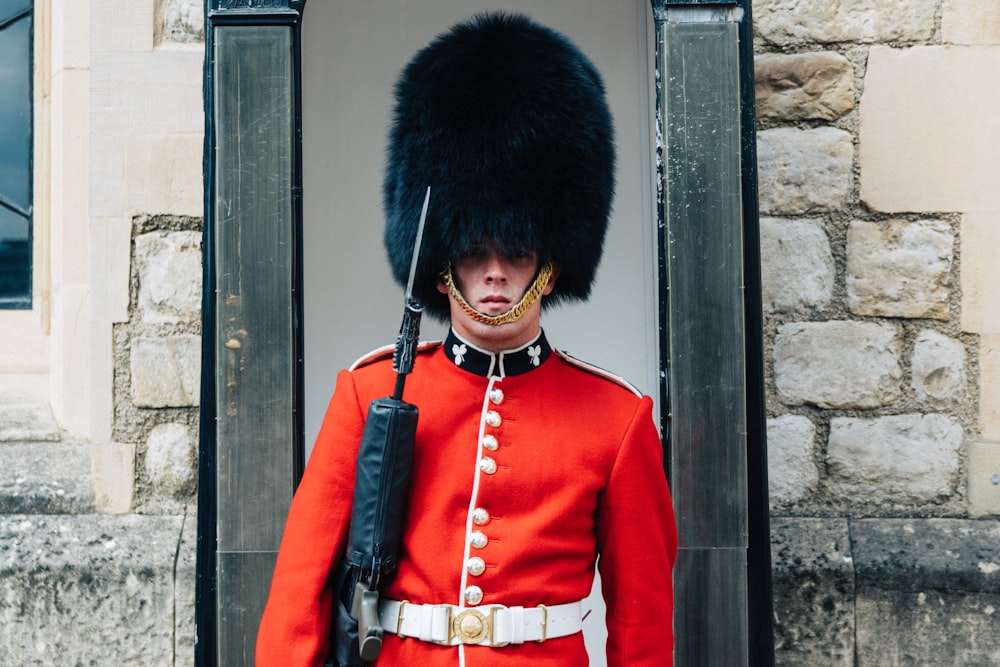 Guardia parado cerca de Brown Wall