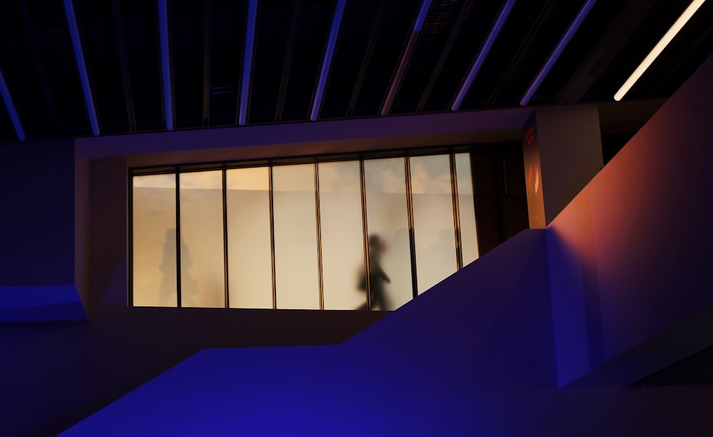 silhouette of two person beyond glass walking on pathway