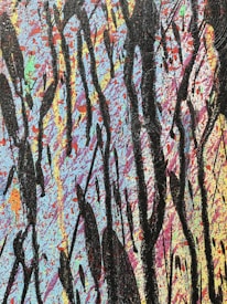 An abstract painting featuring a vibrant background filled with splatters of blue, pink, orange, and other colors. Large, bold black streaks and drips are layered over the colorful backdrop, creating a striking contrast.