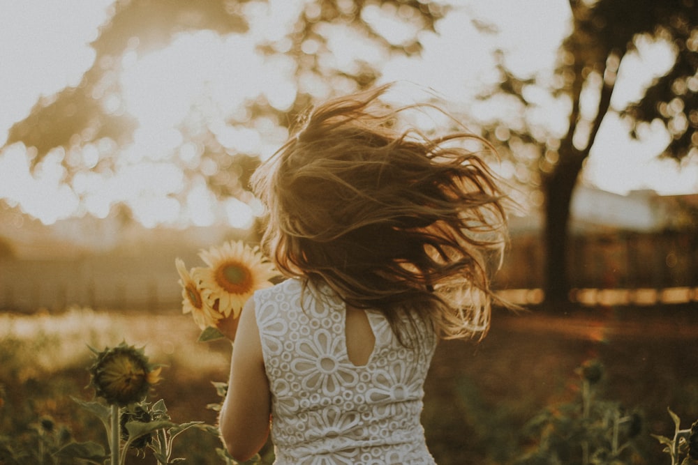 woman holding sunflower during daytime