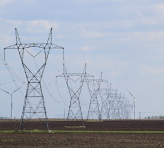 transmission towers and wind turbines on the field