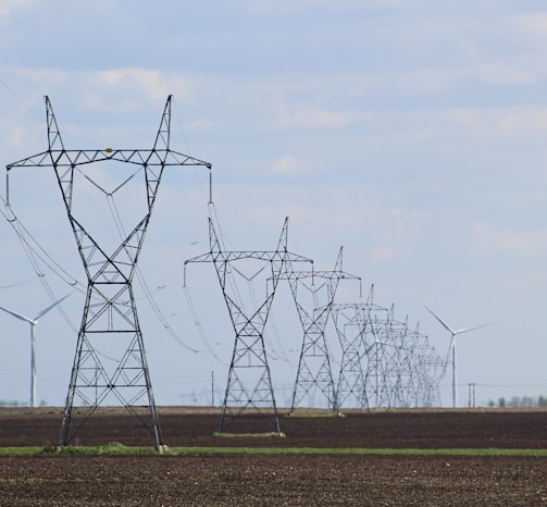 transmission towers and wind turbines on the field