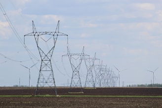 transmission towers and wind turbines on the field