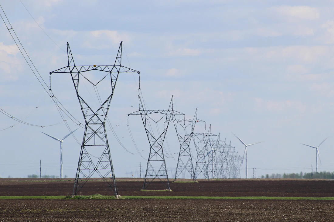 Transmission towers and wind turbines across open farmland