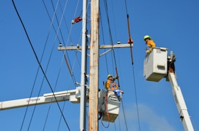 two linemen on cherry pickers