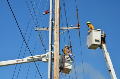 two linemen on cherry pickers