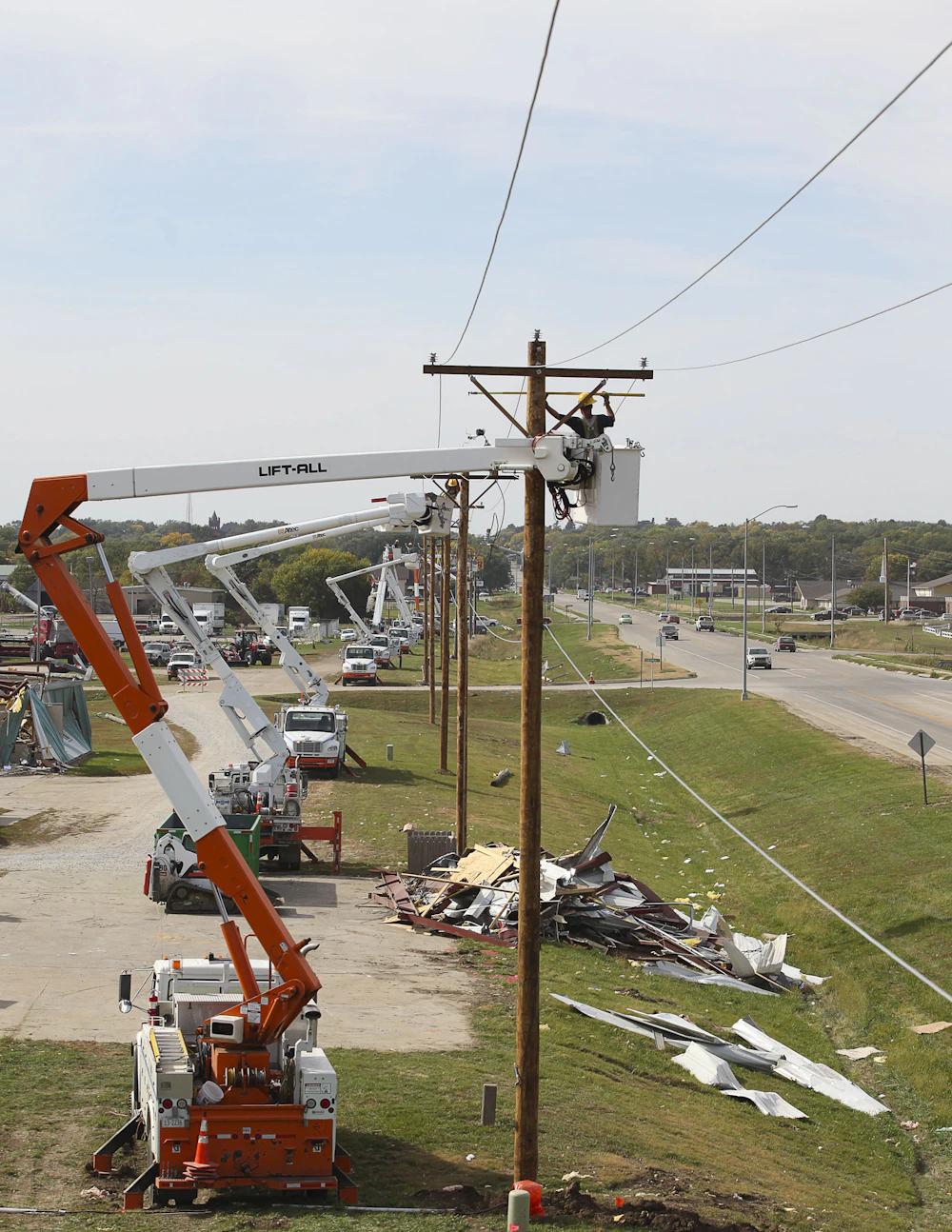 Utility crews restoring power lines from bucket trucks after a major storm