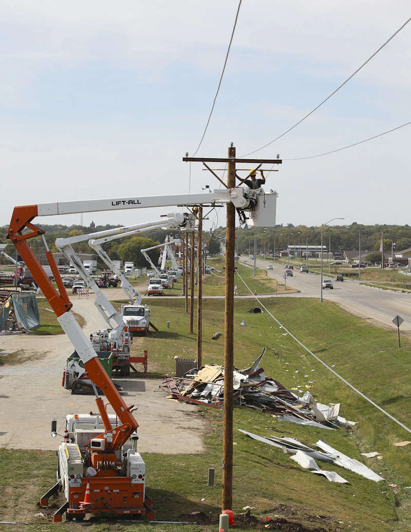 Utility crews restoring power lines from bucket trucks after a major storm