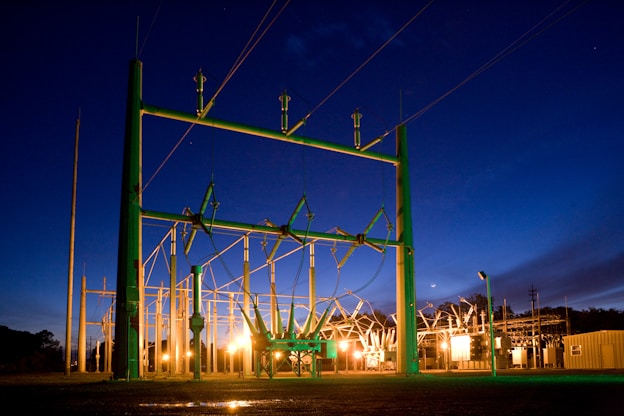 green and grey transmission tower during nighttime