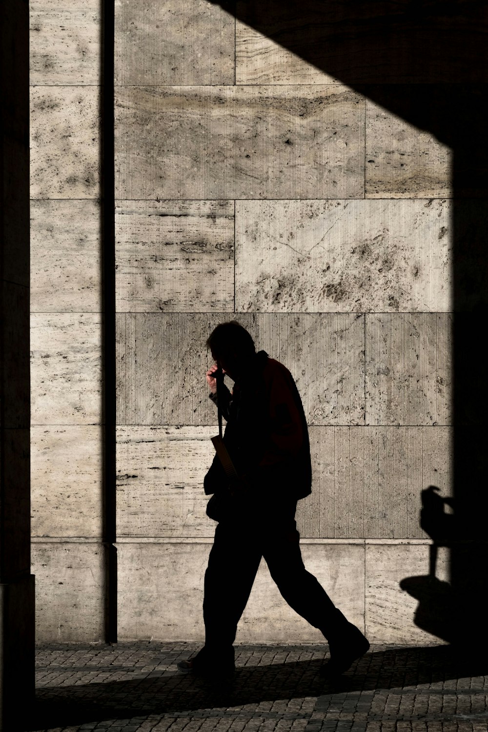 shadow of man walking near wall