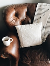 square white throw pillow on brown leather sofa chair