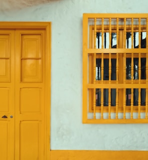 yellow 8-panel door beside window