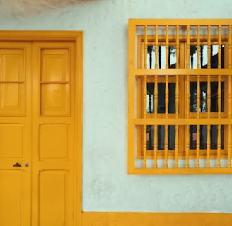 yellow 8-panel door beside window