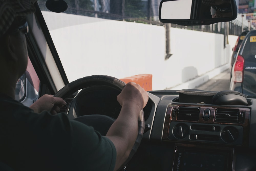 person driving vehicle on road near vehicle at daytime