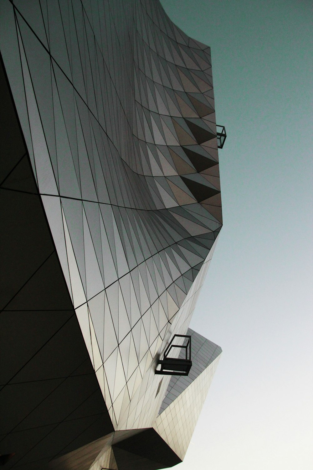 Edificio de cristal bajo el cielo blanco durante el día