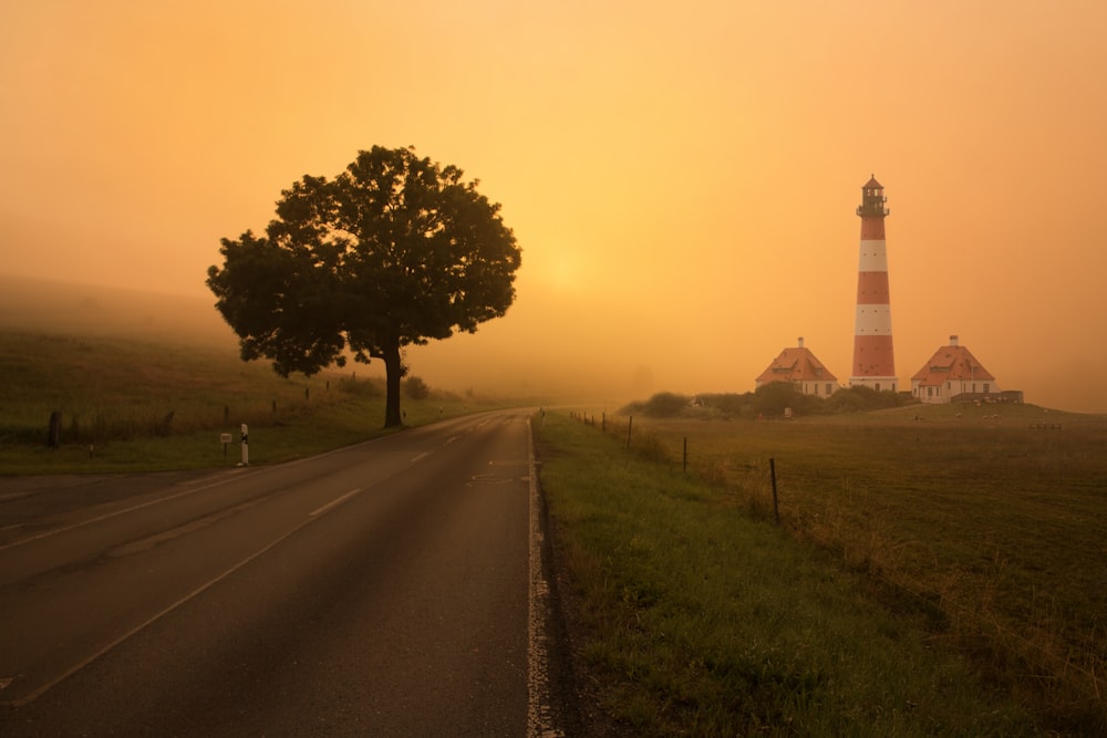 empty roadway with lighthouse and two houses