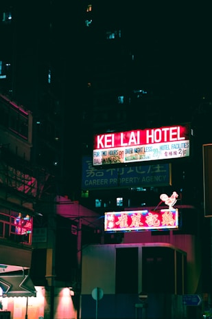 An atmospheric nighttime scene with glowing neon signs in pixel art style.