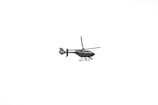 A black helicopter with visible rotors and landing skids is flying against a stark white background. The helicopter is detailed and appears to have a word inscribed on its side.