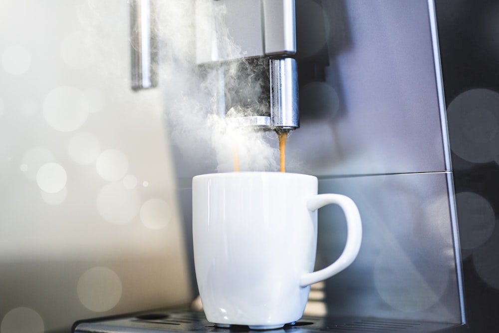 white coffee mug on coffeemaker