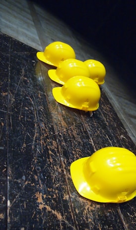 five yellow hard hats on gray surface