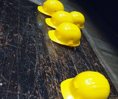 five yellow hard hats on gray surface