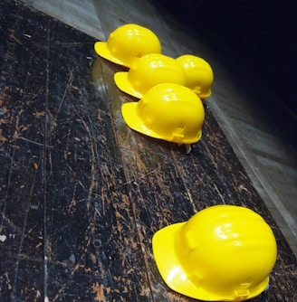 five yellow hard hats on gray surface