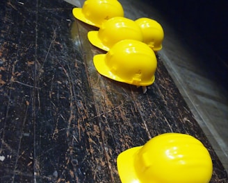 five yellow hard hats on gray surface