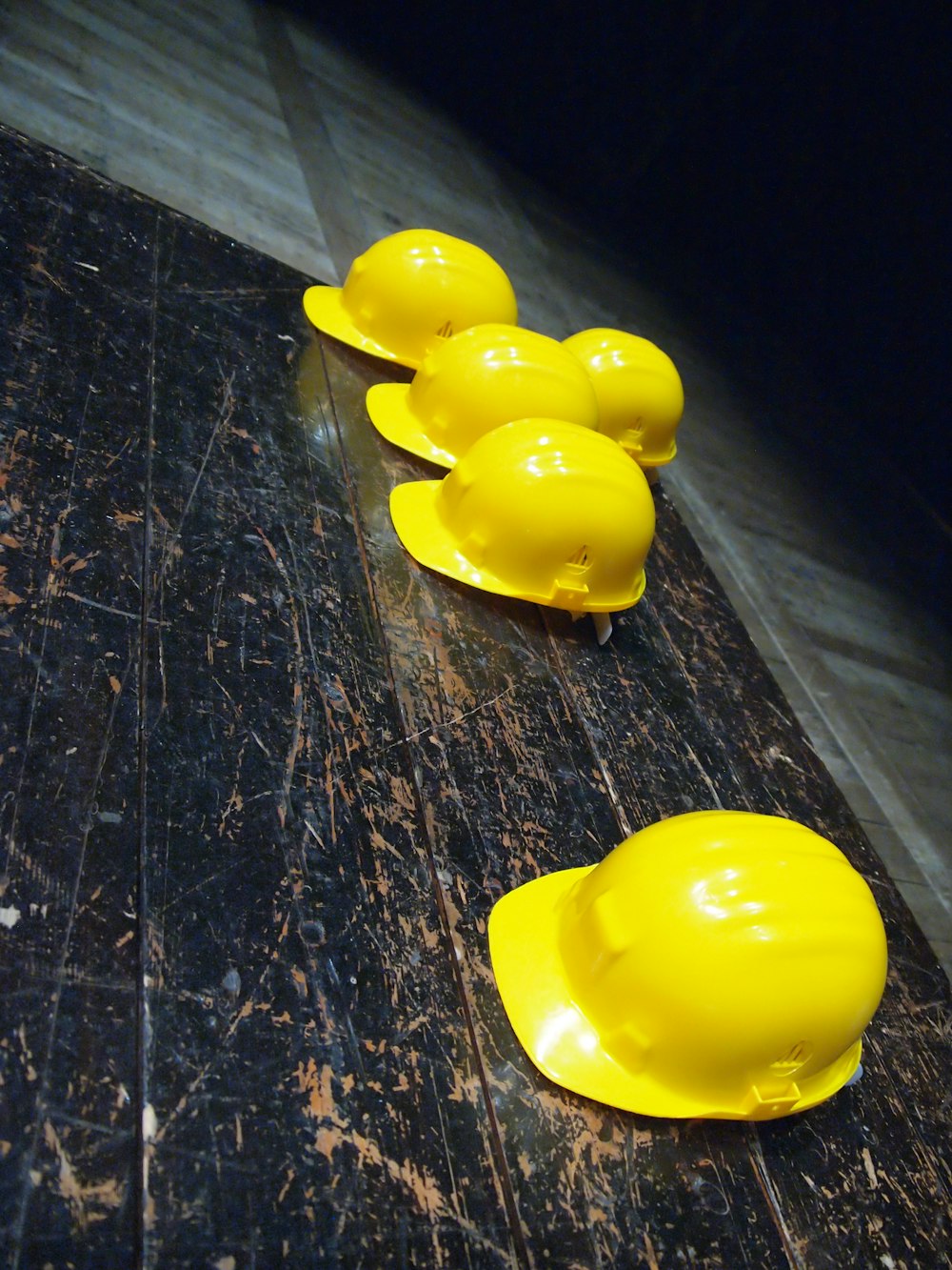 five yellow hard hats on gray surface